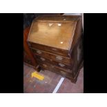 An antique bureau with fitted interior and drawers