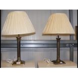 A pair of metal table lamps with shades