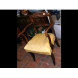 An antique carver chair with sabre front supports