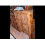 A rustic pine cupboard enclosed by a pair of doors