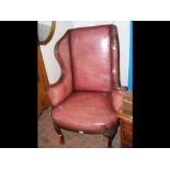 An antique wing easy chair with carved cabriole fr