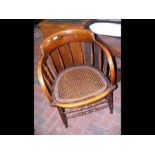 A curved back chair with cane work seat