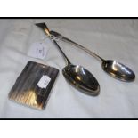 Two silver table spoons together with a cigarette