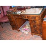 A reproduction pedestal desk with nine drawers to