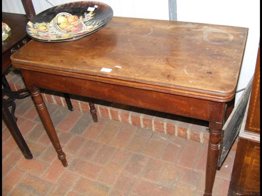 A 19th century mahogany fold-over tea table on tur