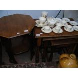 A nest of oak occasional tables together with an o