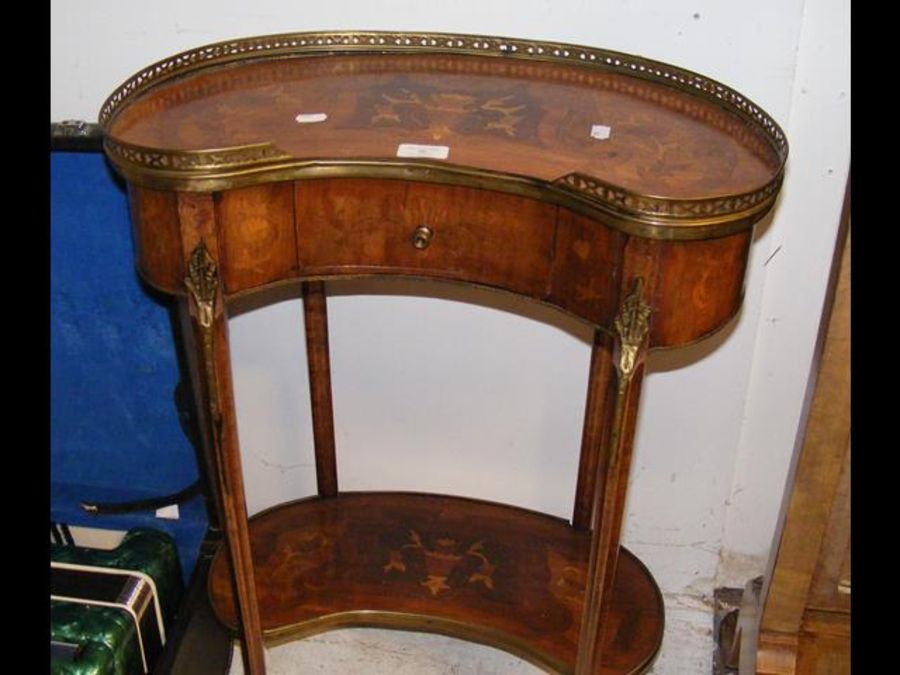 A small kidney shaped two tier occasional table wi