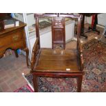 A Chinese hardwood armchair with decoratively carv