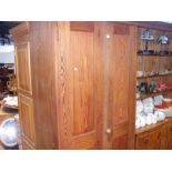 An antique pitch pine two door school cupboard -