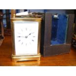 A 15cm high brass cased carriage clock in travelli