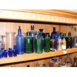 A shelf containing various antique chemist bottles