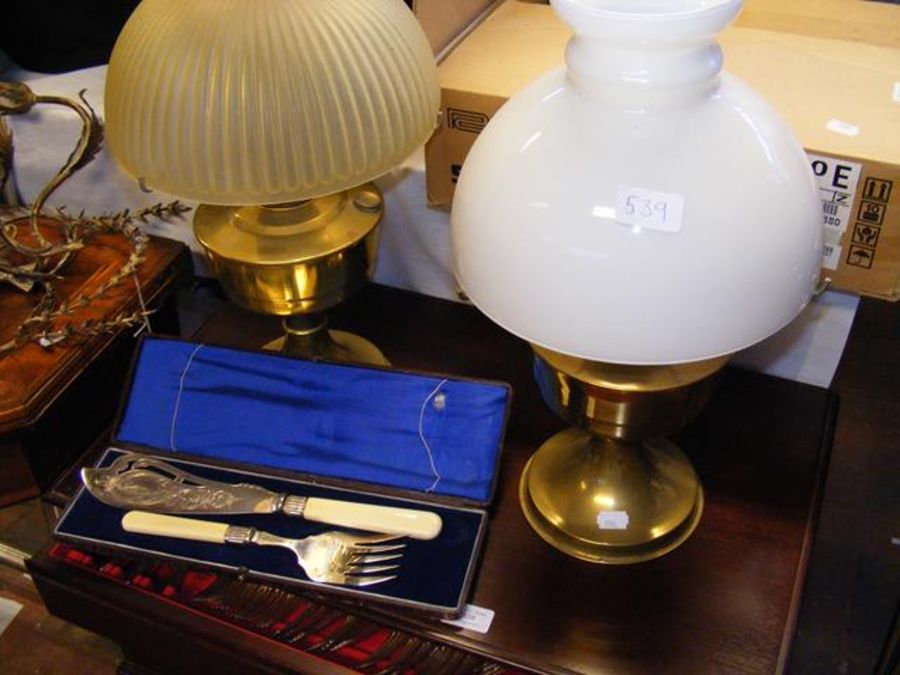 Two oil lamps, together with a pair of fish server