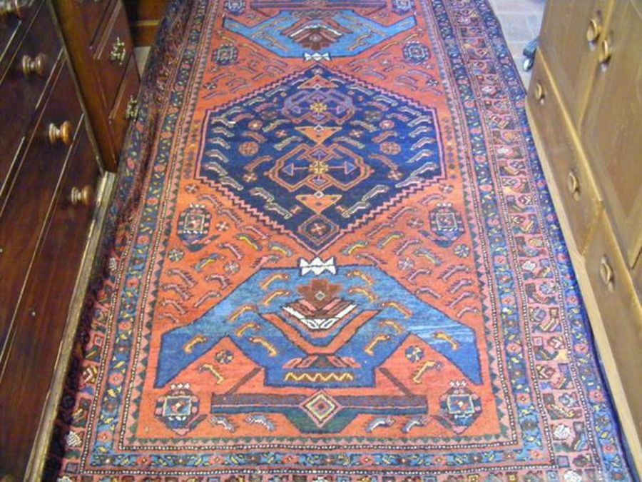 A Persian Hamedan rug with red ground and geometri