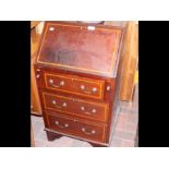 An Edwardian inlaid mahogany bureau with three dra