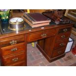 An antique pedestal desk with nine drawers to the