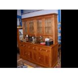 A pine dresser with glazed cupboards to top, drawe
