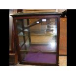 An antique hanging display cabinet with glass shel