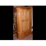 A pine wardrobe enclosed by a pair of panelled doo