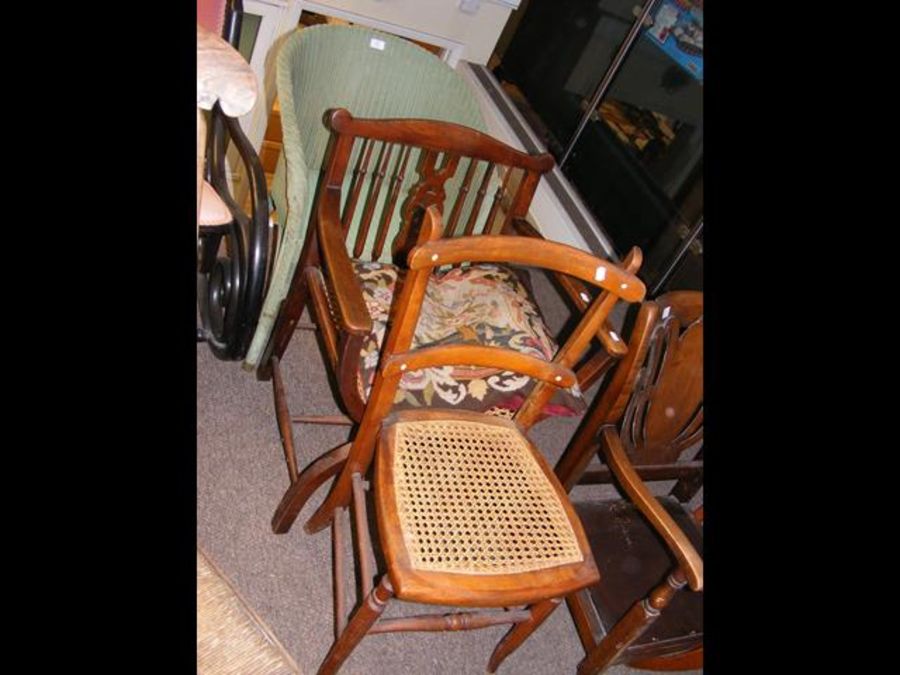 A Lloyd Loom armchair in green, together with two