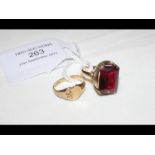 A red stone dress ring in gold setting together wi