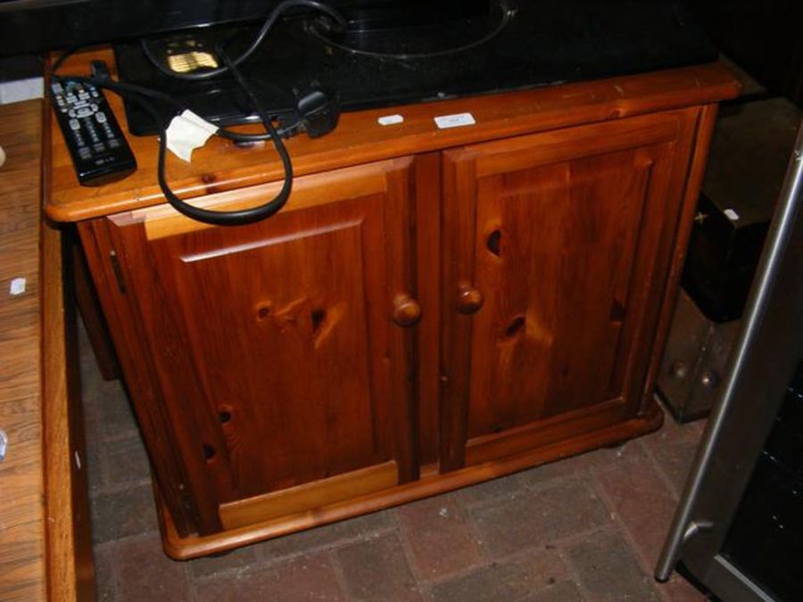 A pine cabinet enclosed by a pair of panelled door