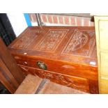 A carved camphorwood Chinese chest with three pane