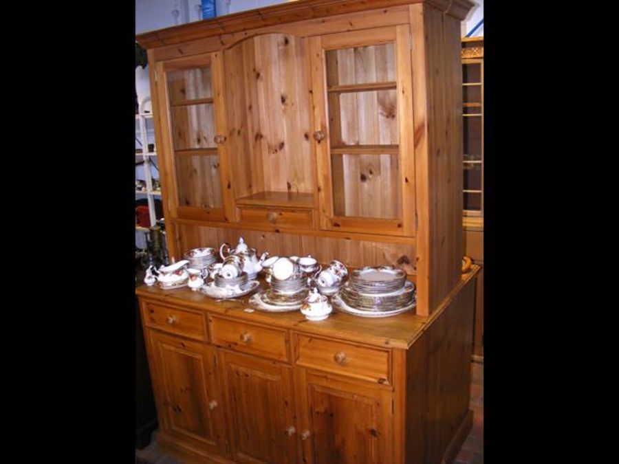 A pine dresser with glazed top, three drawers and