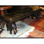 A large Indian 'elephant' table with carved top -