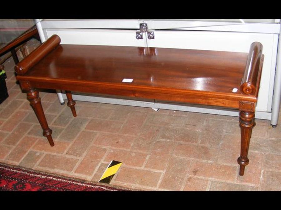 A mahogany window seat on turned support