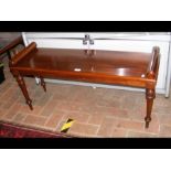 A mahogany window seat on turned support