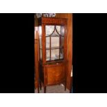 An Edwardian bow fronted display cabinet with inla