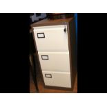A three drawer metal filing cabinet in cream and b