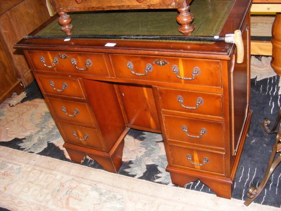 A reproduction pedestal desk with inset green leat