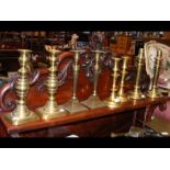 Four pairs of antique brass candlesticks