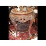 A large carved two tier occasional table - 80cm di