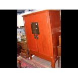 An antique Chinese red lacquered two door wardrobe
