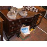 A mahogany seven drawer desk with ball and claw feet