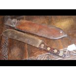 An early 20th century machete in leather scabbard