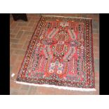 A Persian Hamedan red ground rug with triple borde