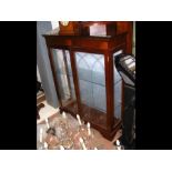 A reproduction mahogany display cabinet enclosed b