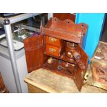 A small antique carved hanging smoker's cupboard