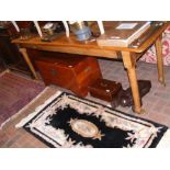 An antique long rectangular kitchen table on turne