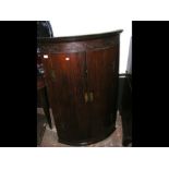 An antique bow fronted hanging corner cupboard