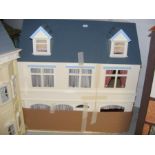 A cream and blue doll's house with boxed contents