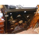 A black lacquered Chinese cabinet with ornate foli