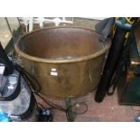 An antique brass cauldron on wrought iron stand