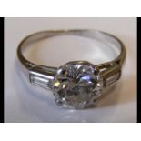 A diamond solitaire ring with diamond baguettes to shoulder - the centre stone approx. 1.5 carat