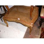 An antique gilt painted stool with rattan top and