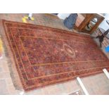 An antique Middle Eastern carpet with red ground a