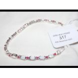 A silver opal and ruby bracelet